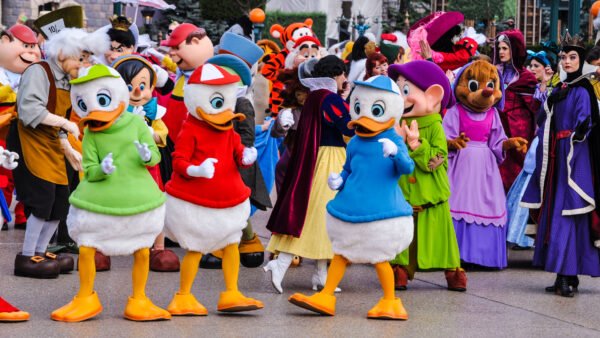 Un groupe de personnes habillées en costumes de Donald Duck déambulant dans Disneyland Paris.