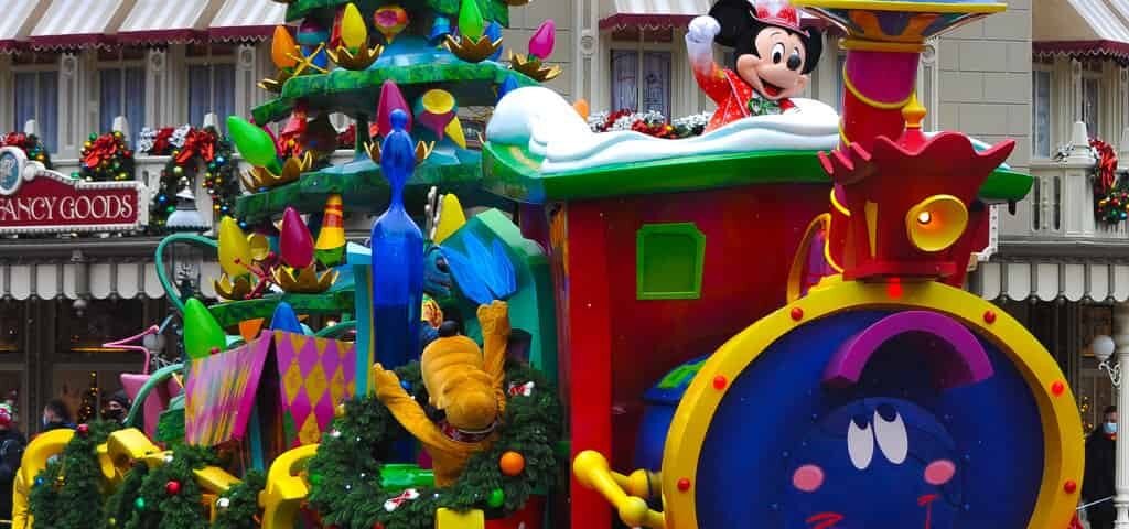 Un train de parade festif avec un sapin de Noël dessus à Disneyland Paris.
