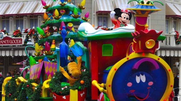 Un train de parade festif avec un sapin de Noël dessus à Disneyland Paris.