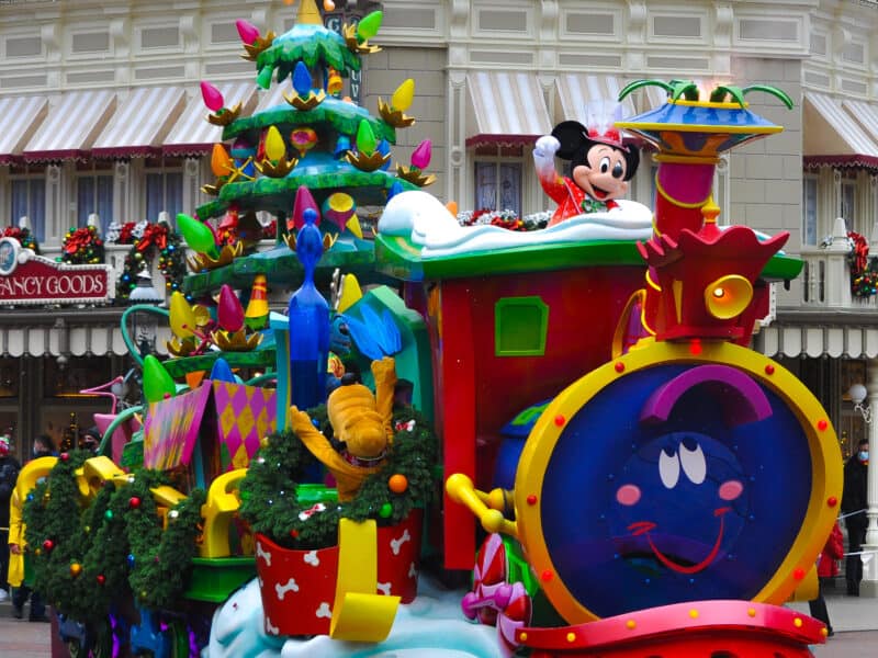 Un train de parade festif avec un sapin de Noël dessus à Disneyland Paris.