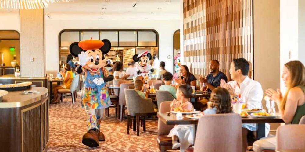 Un groupe de personnes dans un restaurant de Walt Disney World, en présence de Mickey Mouse.