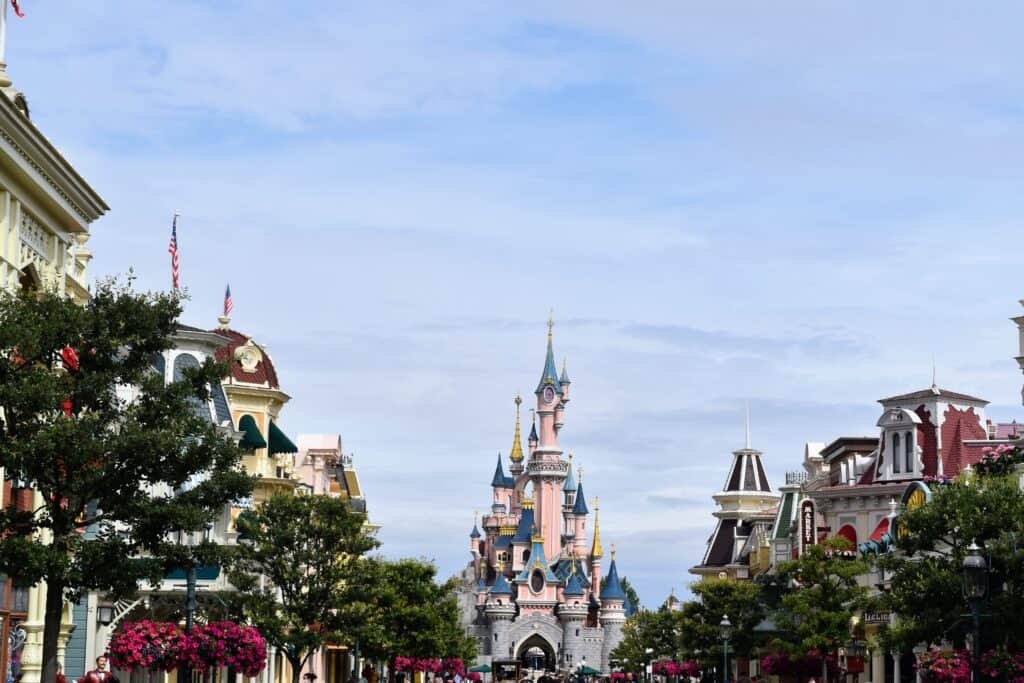 Affluence 2024. Une superbe rue de Disneyland Paris avec un majestueux château en arrière-plan.
