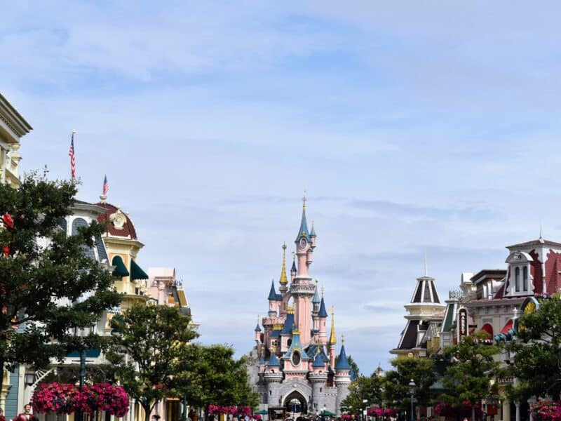 Affluence 2024. Une superbe rue de Disneyland Paris avec un majestueux château en arrière-plan.