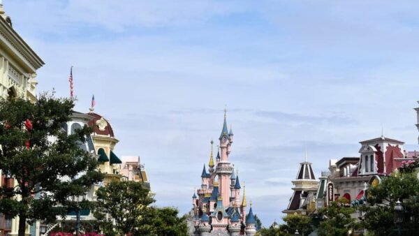 Affluence 2024. Une superbe rue de Disneyland Paris avec un majestueux château en arrière-plan.