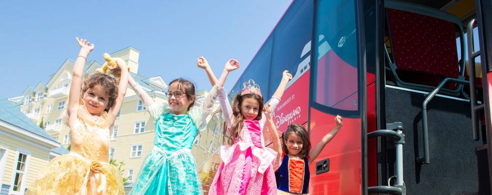 Un groupe d'enfants déguisés en princesse empruntant une navette magique pour Disneyland Paris.