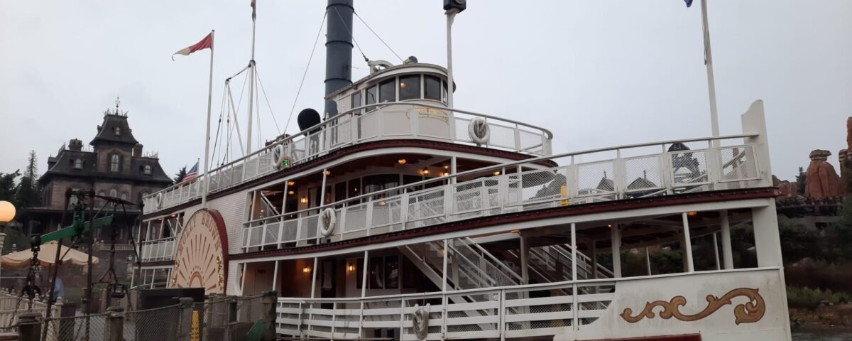 Un bateau à vapeur est amarré à un quai un jour de pluie à Disneyland Paris.