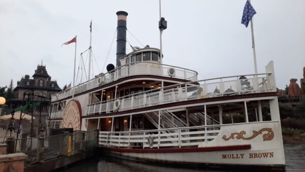Un bateau à vapeur est amarré à un quai un jour de pluie à Disneyland Paris.