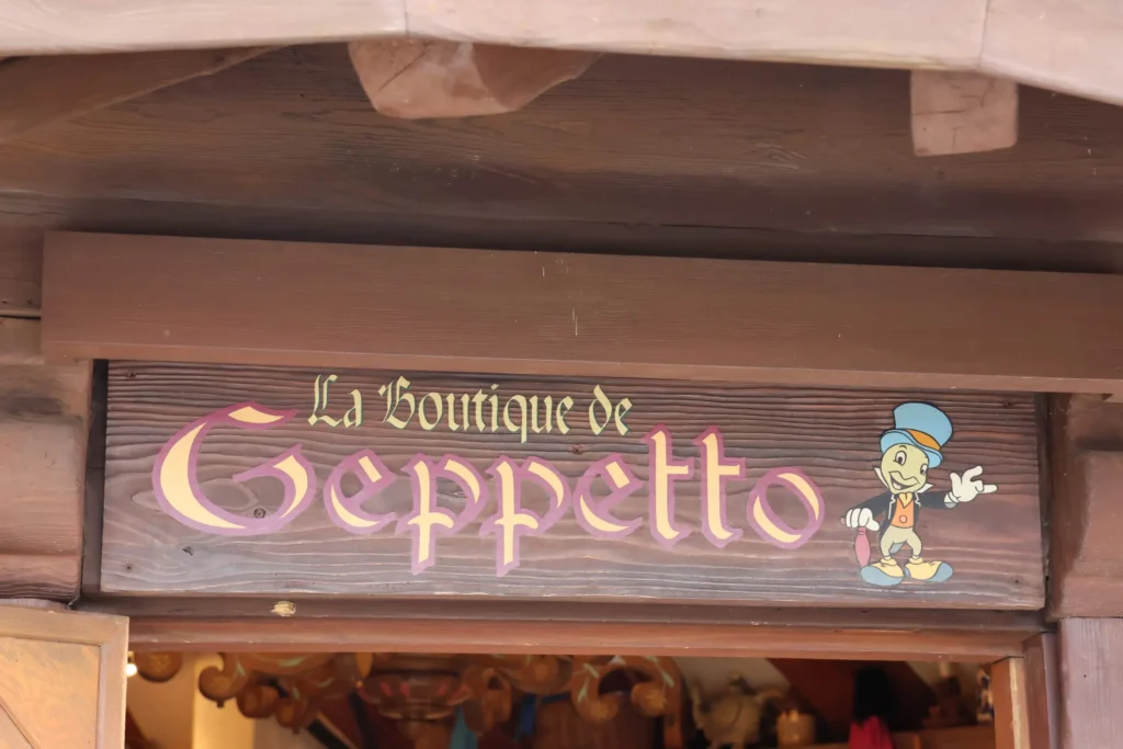 Une pancarte indiquant Gepetto sur une porte en bois, située dans la boutique Disneyland Paris de Gepetto.