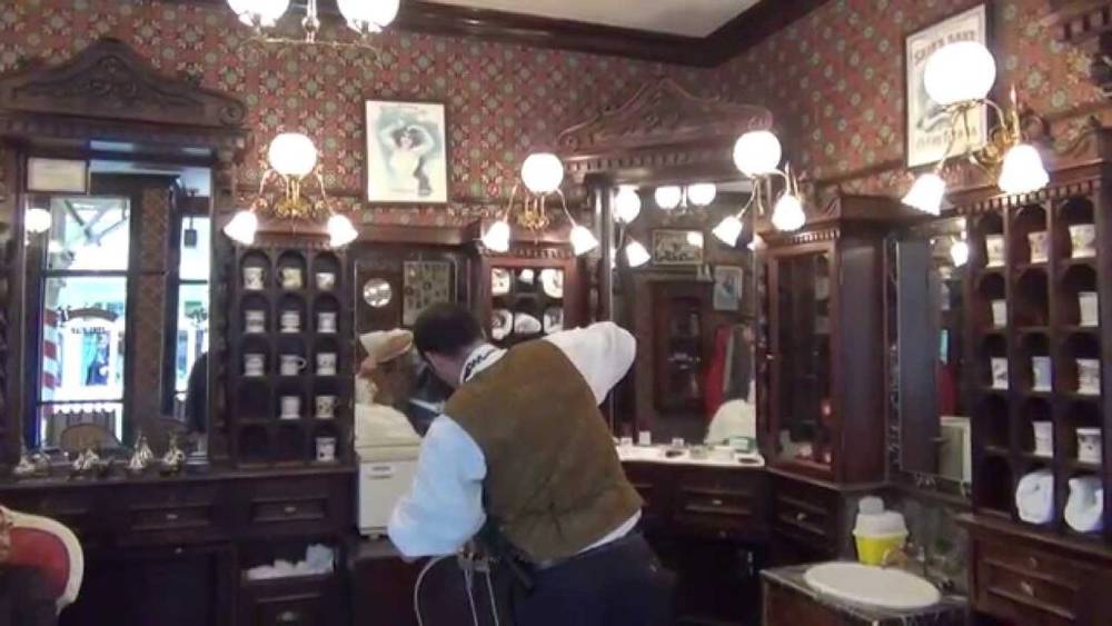 Un homme se fait couper les cheveux chez Dapper's Dan Haircuts, un salon de coiffure.