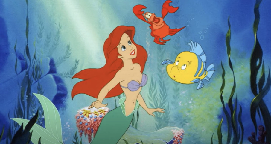 Ariel, la sirène rousse de "La Petite Sirène" de Disney, nage sous l'eau accompagnée de ses amis, le crabe Sébastien et le poisson Flet, sur fond de plantes océaniques et