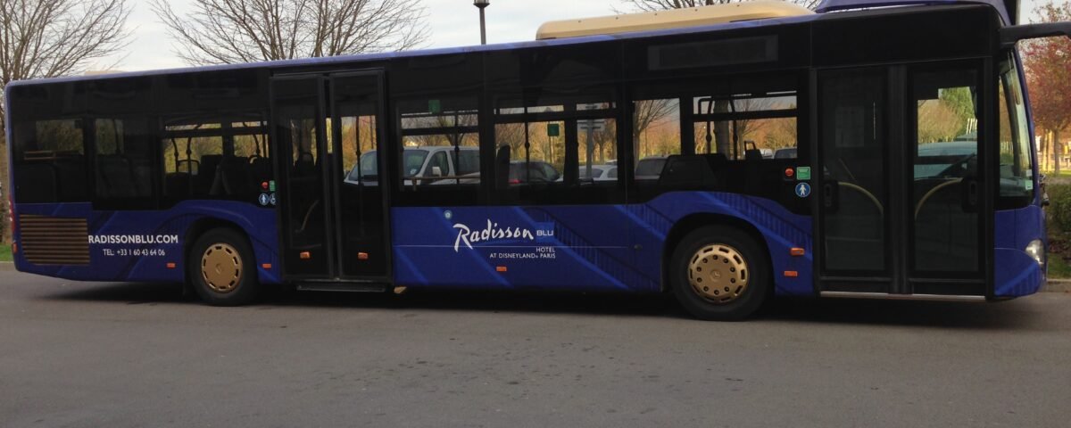 Un bus bleu garé dans un parking proche de Disneyland Paris.