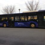 Un bus bleu garé dans un parking proche de Disneyland Paris.
