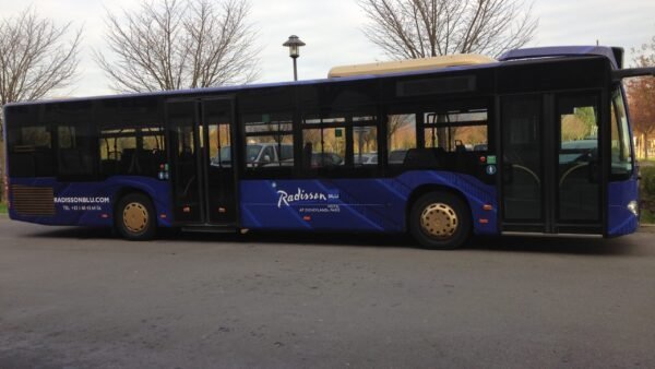 Un bus bleu garé dans un parking proche de Disneyland Paris.