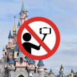 Un panneau d'interdiction sur Disneyland Paris indiquant qu'aucun selfie ou perche à selfie n'est autorisé. Le panneau représente une caméra avec une barre oblique et une personne assise, également barrée.