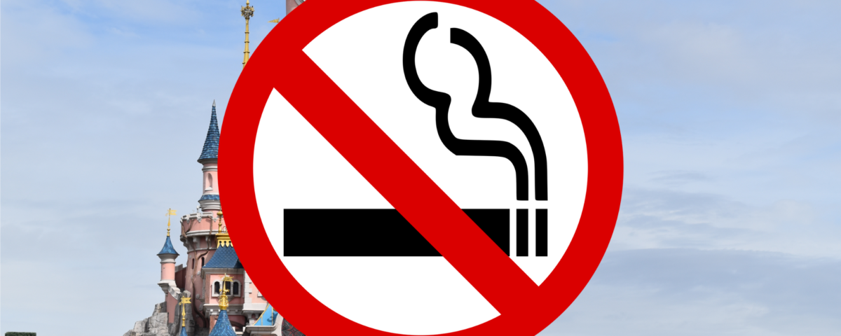 Une enseigne non-fumeur superposée sur une image de fond représentant un château de conte de fées au ciel nuageux.