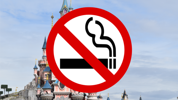 Une enseigne non-fumeur superposée sur une image de fond représentant un château de conte de fées au ciel nuageux.