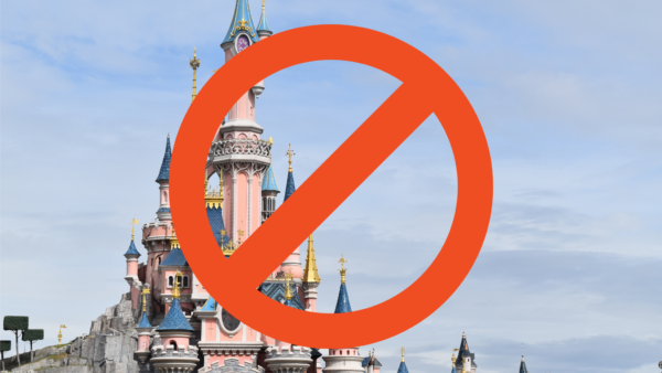 Un panneau d'interdiction rouge recouvre une photo de Disneyland Paris avec des flèches colorées sous un ciel bleu avec des nuages.