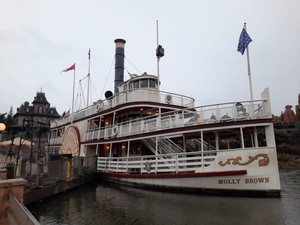 Conseils visite Disneyland Paris. Un bateau à vapeur est amarré à un quai un jour de pluie.