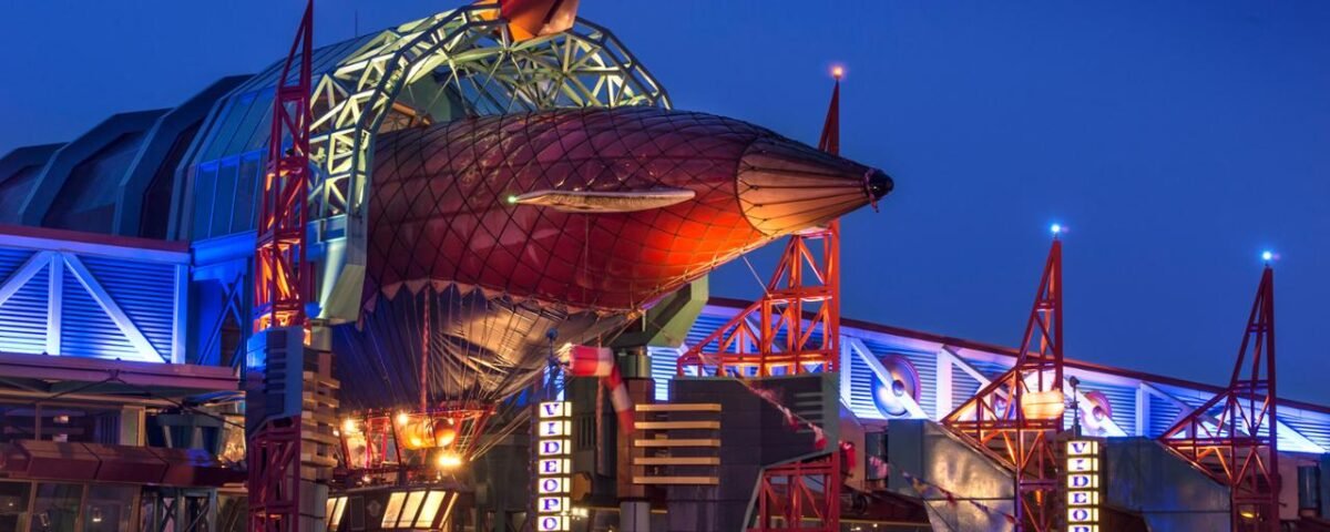 Le Café Hyperion, un grand bâtiment de Disneyland Paris, illuminé la nuit.