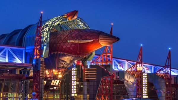 Le Café Hyperion, un grand bâtiment de Disneyland Paris, illuminé la nuit.