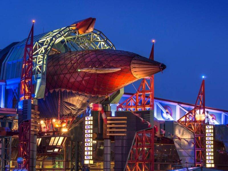 Le Café Hyperion, un grand bâtiment de Disneyland Paris, illuminé la nuit.