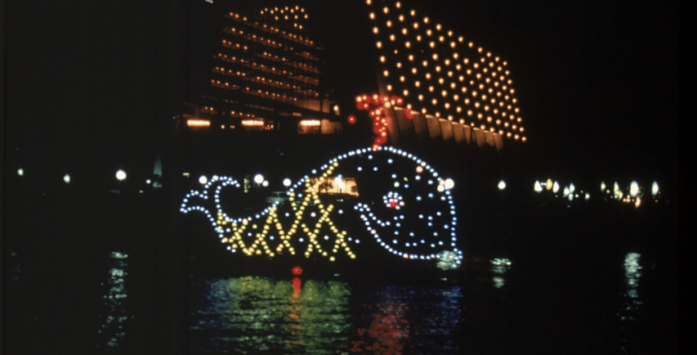 À Disneyland Paris, un bateau illuminé représentant une majestueuse baleine se démarque lors des festivités vibrantes et colorées de l'année haute en couleurs.