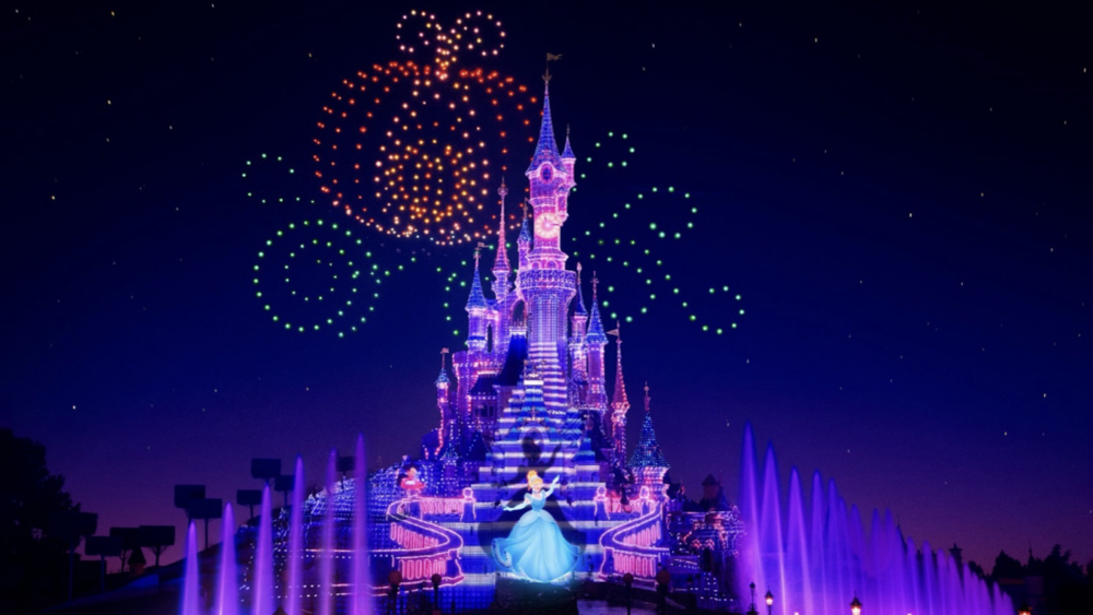 Le Château de Cendrillon de Disney à Disneyland Paris, illuminé de couleurs vives et accompagné d'un spectaculaire feu d'artifice pendant l'année haute.