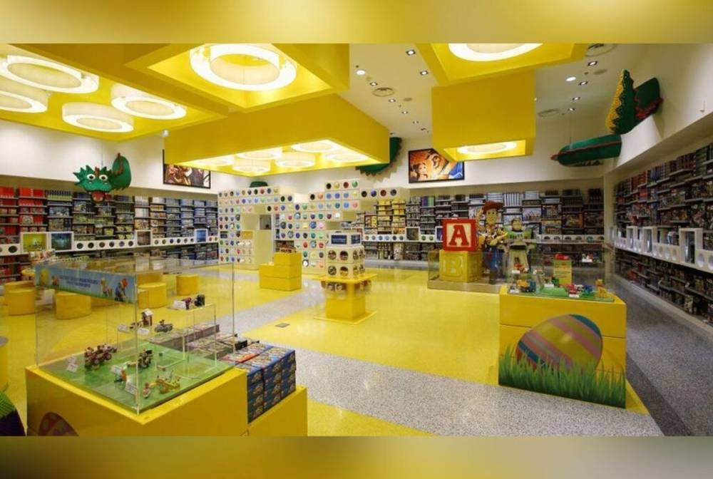 Un magasin Lego à Disney Village avec des murs et des étagères jaunes.