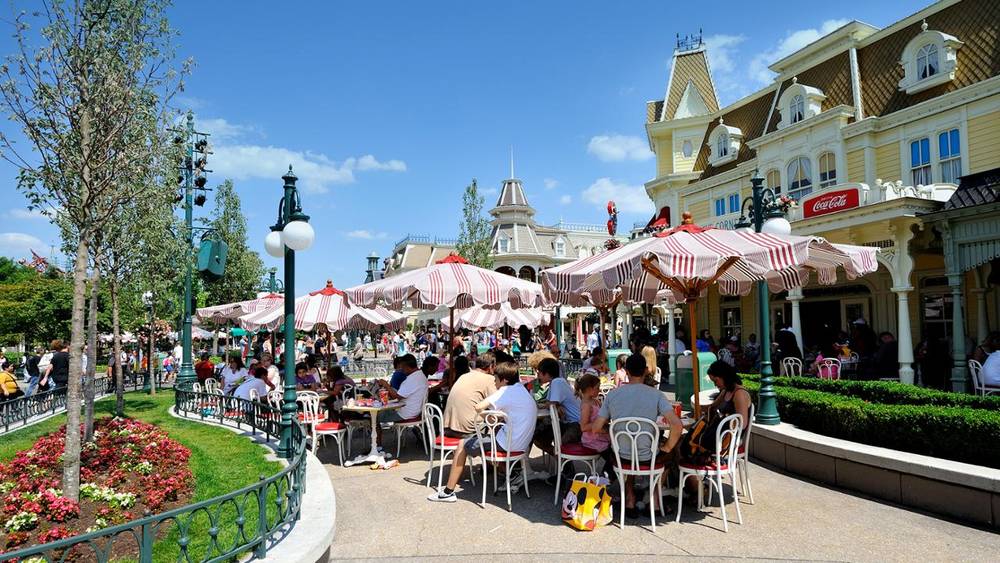 Un groupe de personnes assises à des tables à Casey's Corner, Disneyland Paris.