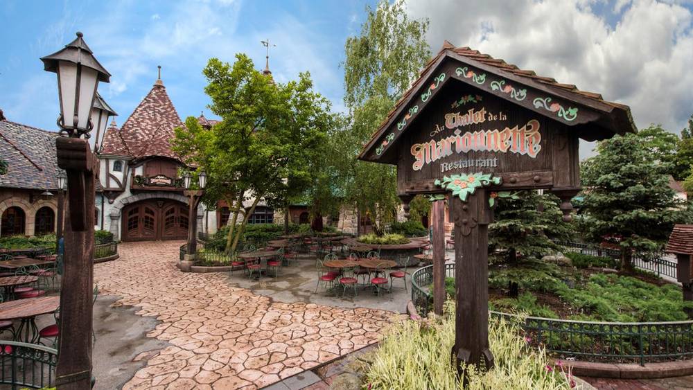 L'entrée d'un village Disney en Californie, présentant des éléments inspirés à la fois de Disneyland Paris et du Chalet de la Marionnette.