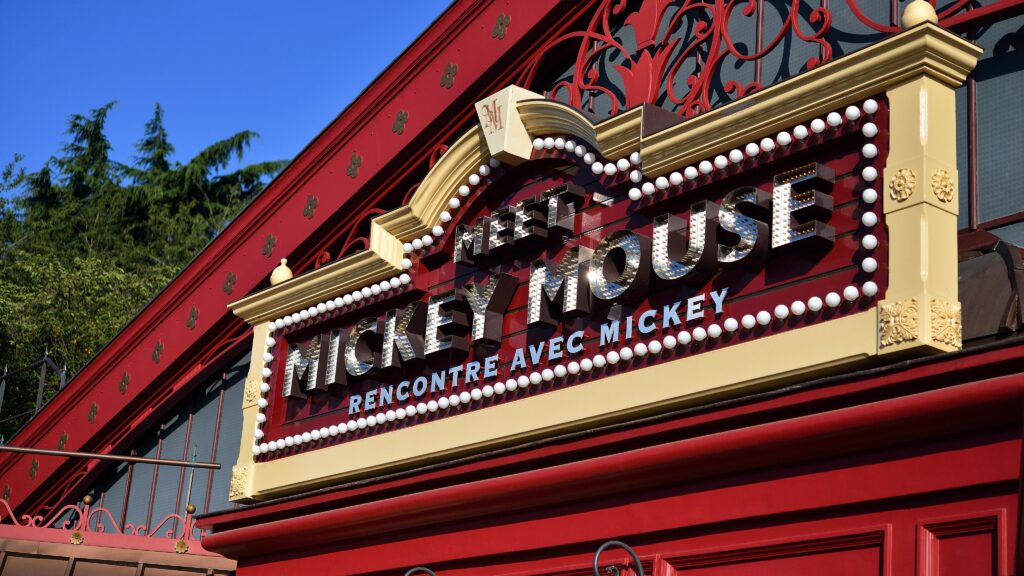 Meet Mickey Mouse Photographs. Un bâtiment rouge avec une pancarte indiquant Mickey House, situé à Disneyland Paris.