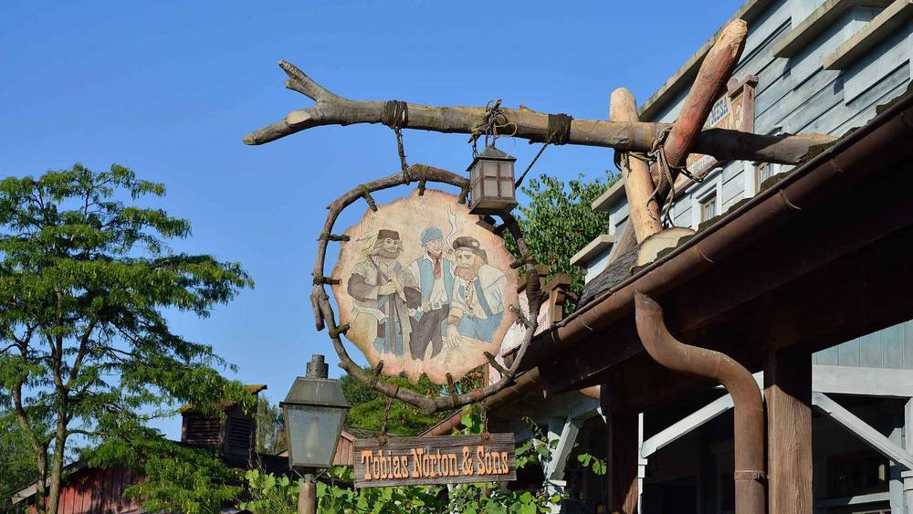 Une pancarte avec une photo d'un homme et d'une femme exposée au Thunder Mesa Mercantile Building à Disneyland Paris.