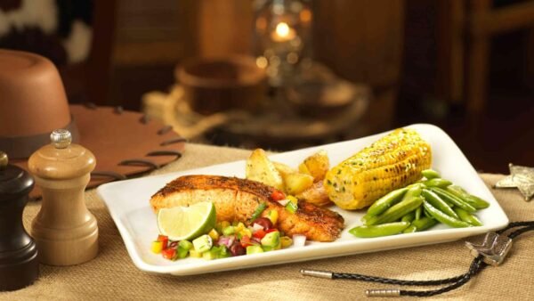 Une assiette de nourriture sur une table à côté d'un chapeau de cowboy au Silver Spur Steakhouse à Disneyland Paris.
