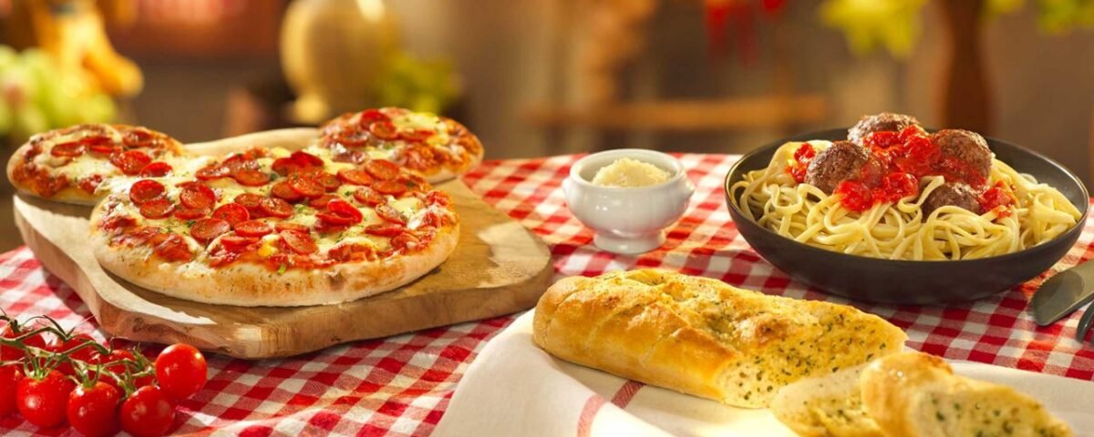 Une table à la Pizzeria Bella Notte à Disneyland Paris avec de la pizza, du pain et d'autres aliments.