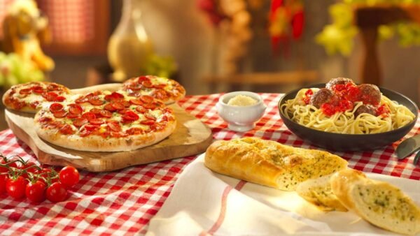 Une table à la Pizzeria Bella Notte à Disneyland Paris avec de la pizza, du pain et d'autres aliments.