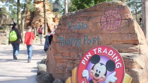 Un groupe de personnes passe devant un panneau indiquant Pueblo Trading Post.