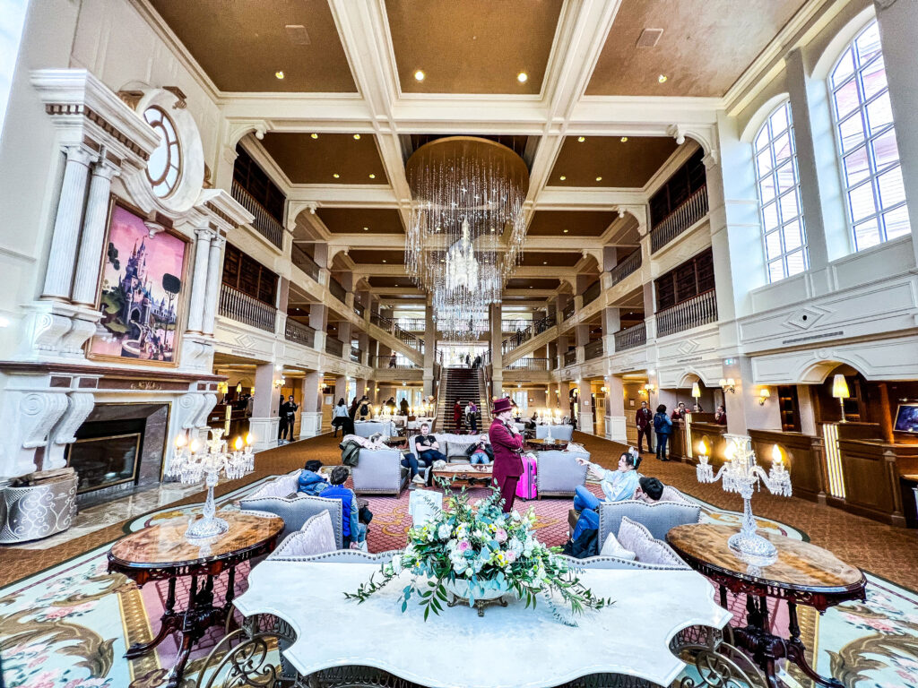 Où loger : Le hall d’un hôtel de Disneyland Paris avec un grand lustre.