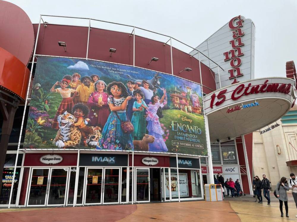 Une salle de cinéma avec une grande affiche annonçant les derniers films.