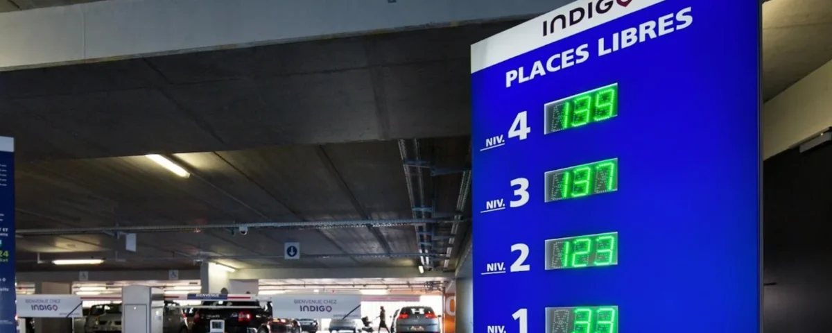 Un panneau de station-service avec une horloge affichée dessus.