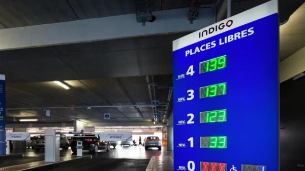 Un panneau de station-service avec une horloge affichée dessus.