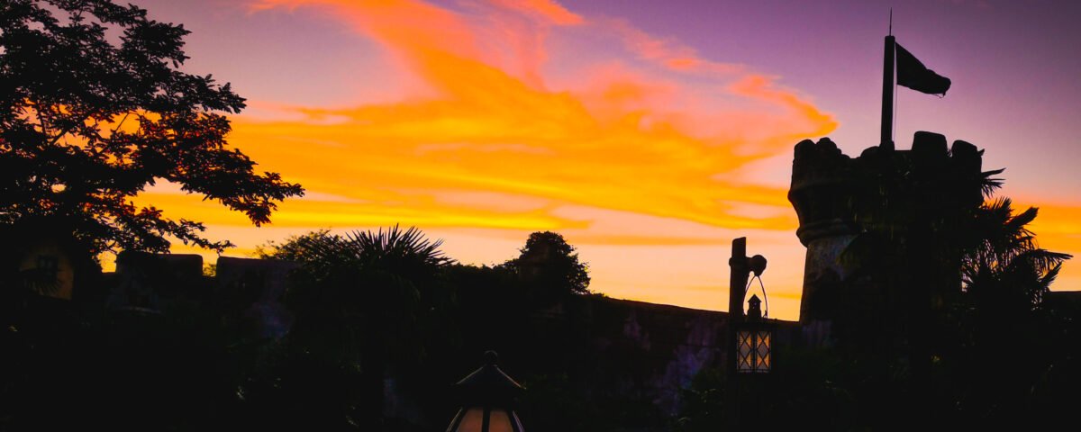 Un coucher de soleil coloré avec un château en arrière-plan à Disneyland Paris.
