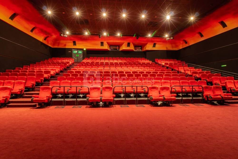 Une salle de cinéma vide avec des sièges rouges au Cinéma Gaumont.