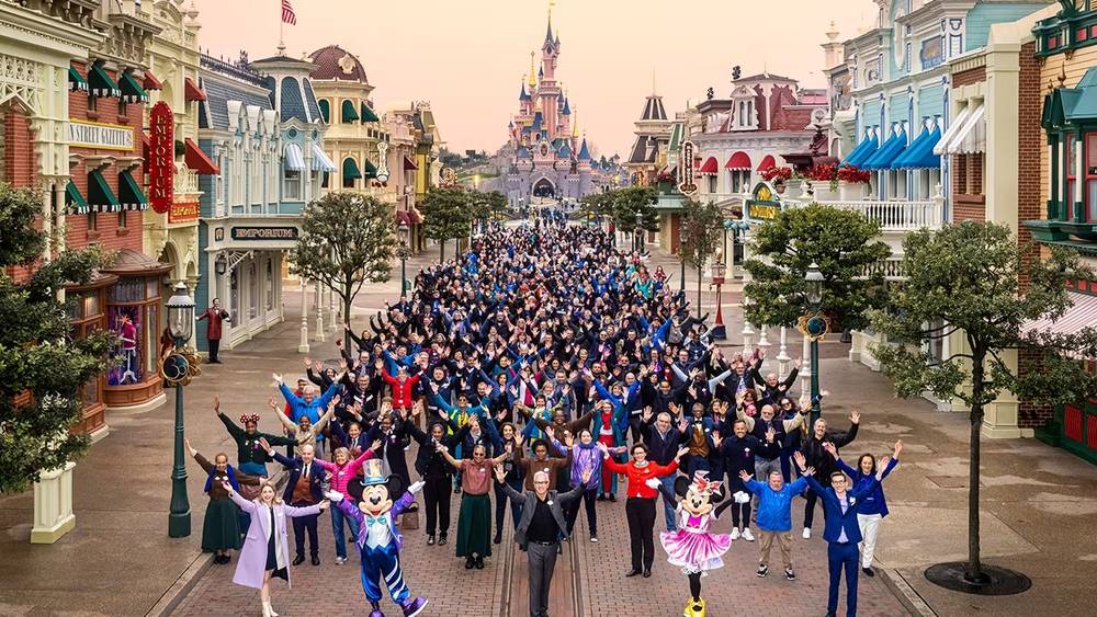 Un groupe de personnes debout dans une rue de Disneyland Paris.