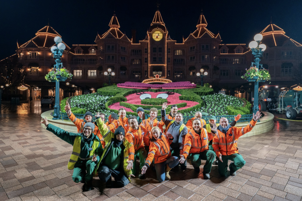 Un groupe de personnes posant devant un château de Disneyland.