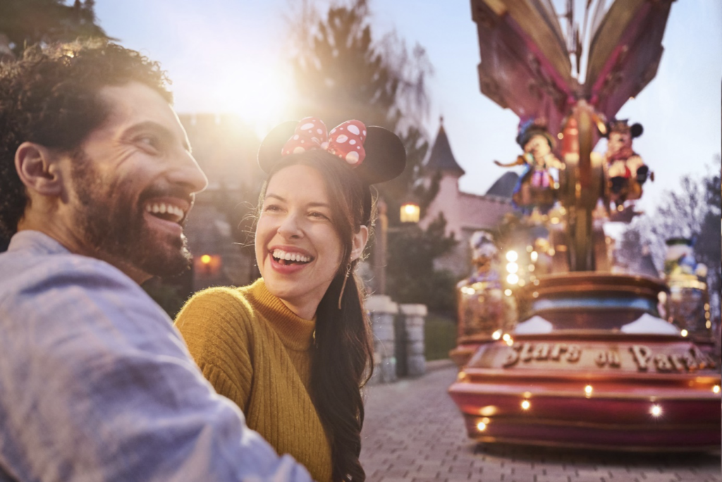 Un couple souriant devant un carrousel à Disneyland Paris avec Mary Poppins.