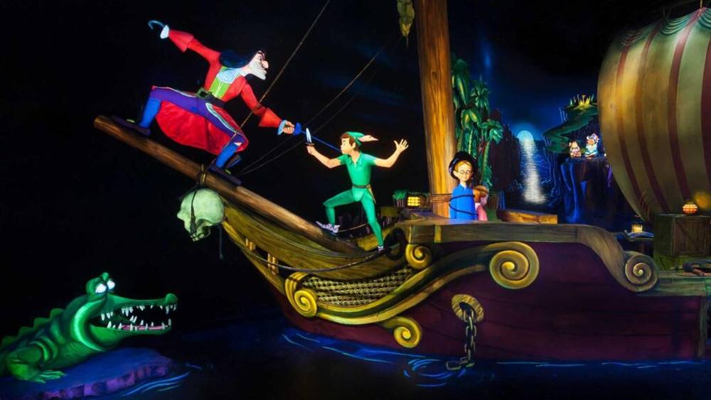 Un diorama coloré mettant en scène des personnages animés du Vol de Peter Pan à Disneyland Paris, avec le Capitaine Crochet en équilibre sur le bastingage d'un navire et Peter Pan sur le pont, tandis que Wendy et un autre personnage observent, et