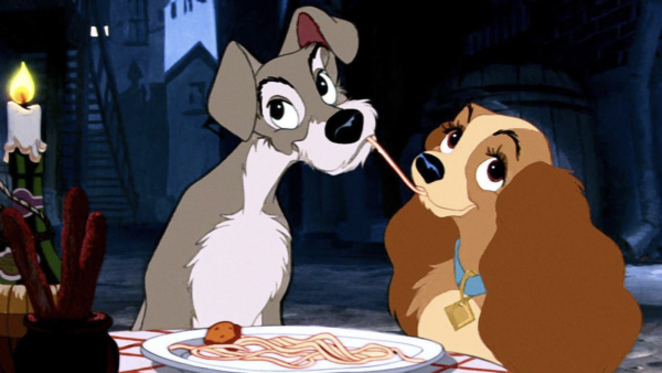 Image animée de La Belle et le Clochard partageant des spaghettis lors d'un dîner aux chandelles, leurs nez se rencontrant au milieu alors qu'ils mangent le même brin de pâtes.