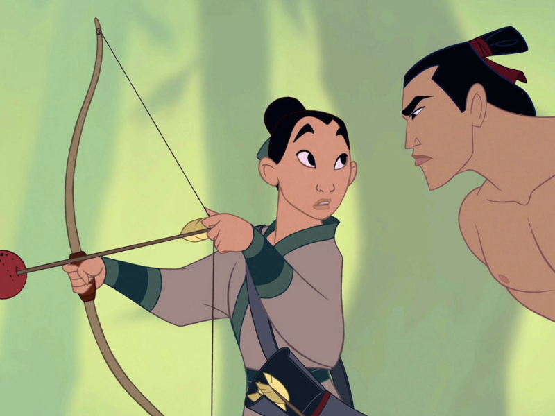 Un personnage animé pratique le tir à l'arc, pointant une flèche sur un fruit tenu par un autre personnage, rappelant les scènes d'entraînement intenses de "Comme Un Homme" de Mulan.