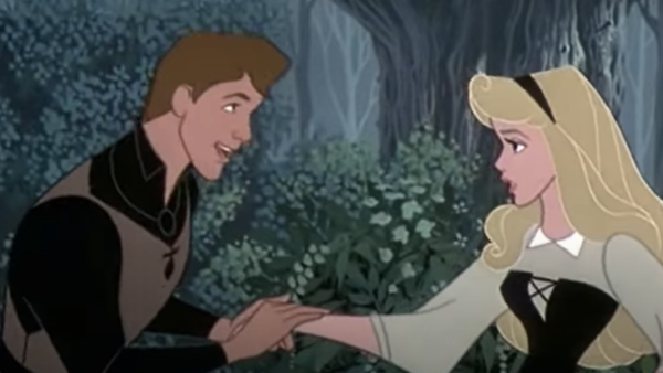 Un homme et une femme se tiennent la main dans une forêt qui n'est pas sans rappeler "La Belle au Bois Dormant". La femme, aux longs cheveux blonds, porte une robe noire et blanche. L'homme, aux cheveux bruns courts et à la tenue marron et noire, la regarde comme s'il lui disait « J'en ai rêvé » pendant qu'ils discutent.