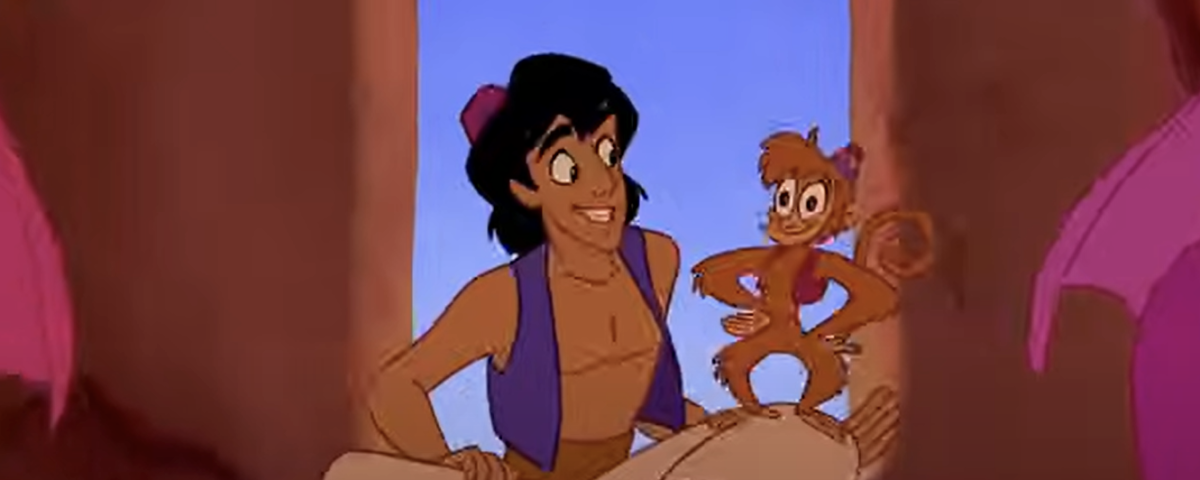 Un jeune homme souriant et animé est assis sur un tapis avec un singe joyeux sur son épaule, rappelant Aladin, à l'intérieur d'une pièce avec une fenêtre cintrée.